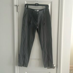 Stretch/techno material straight leg pants. Zip pockets and legs. Low rise.
